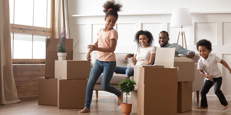 African american family in new house with children running around and boxes all around