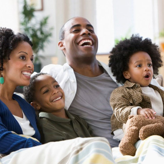 happy black family smiling sitting on couch