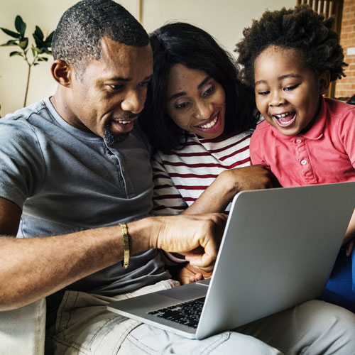 black-copule-on-couch-with-kid-viewing-computer