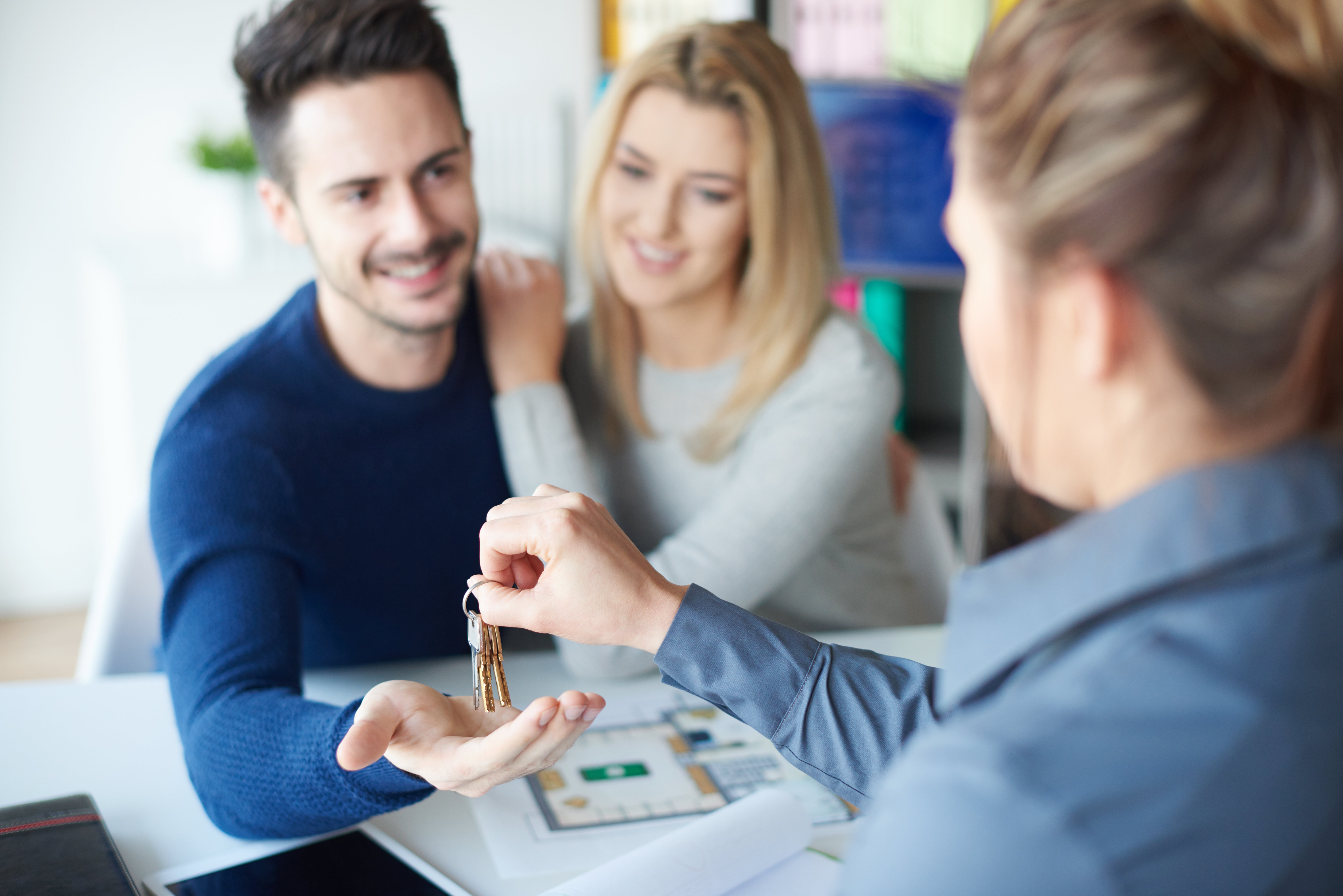 female-realtor-handing-keyring-to-man-2021-08-26-20-15-20-utc