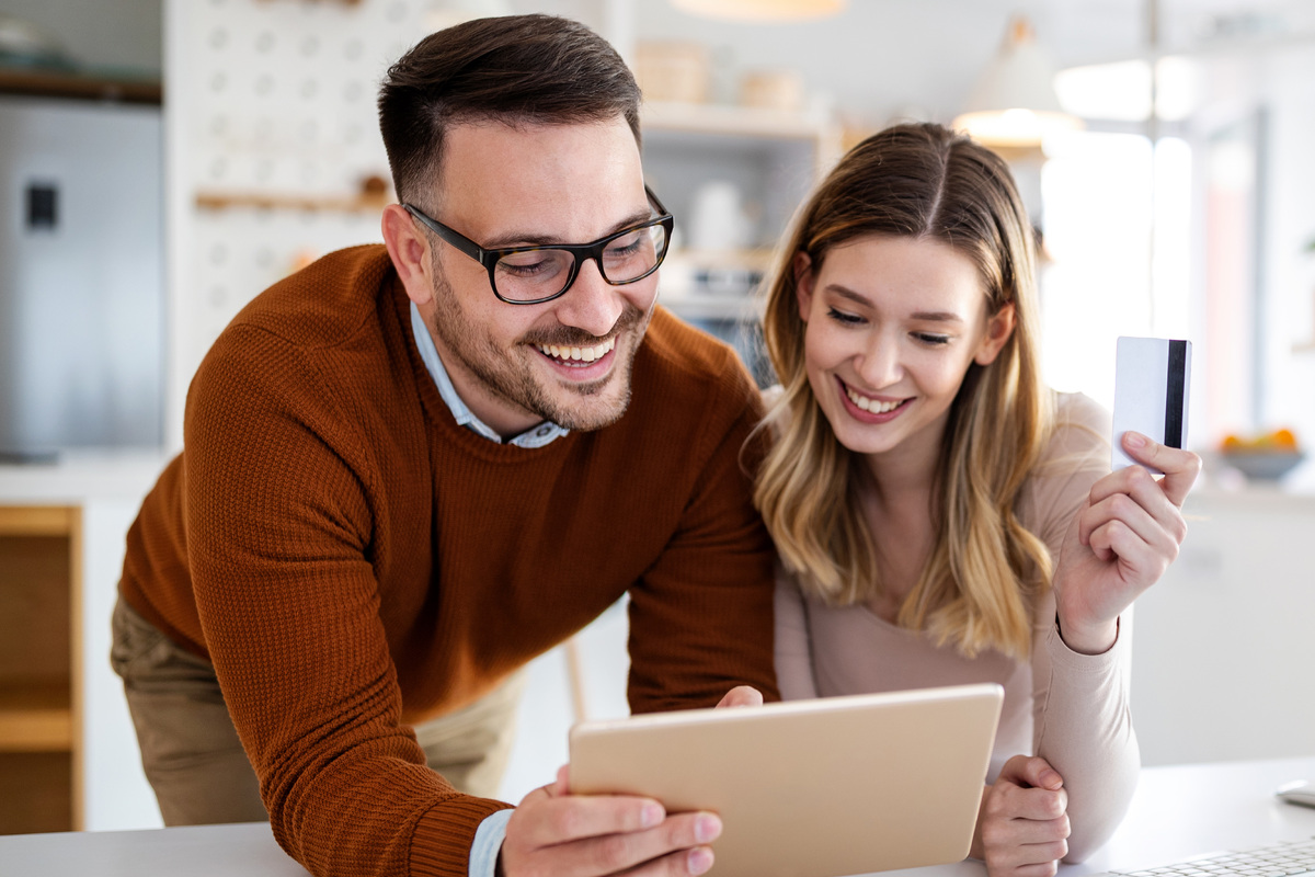 portrait of a cheerful couple shopping on tablet
