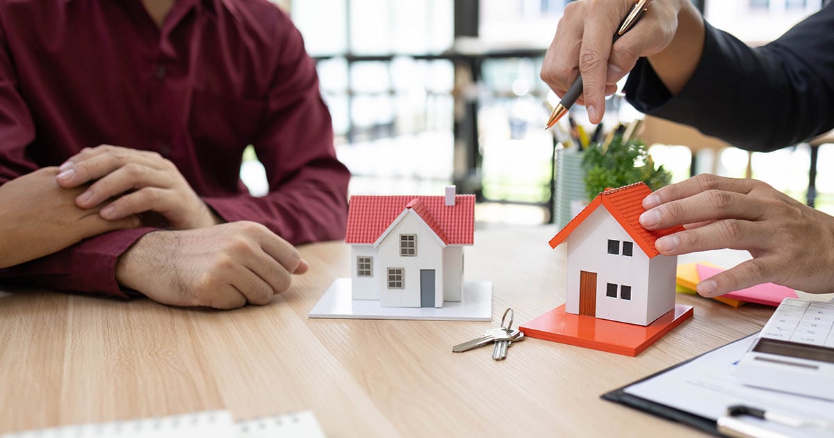salesperson is making a sale to potential buyers by showing them a model home and making an offer