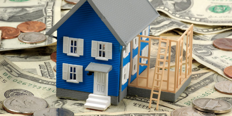 house figure sitting on top of cash