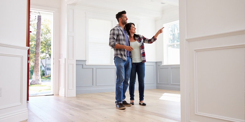 Couple pointing at details in beautiful lit empty home