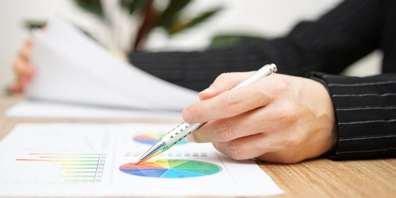 Man pointing at graph on table with pen