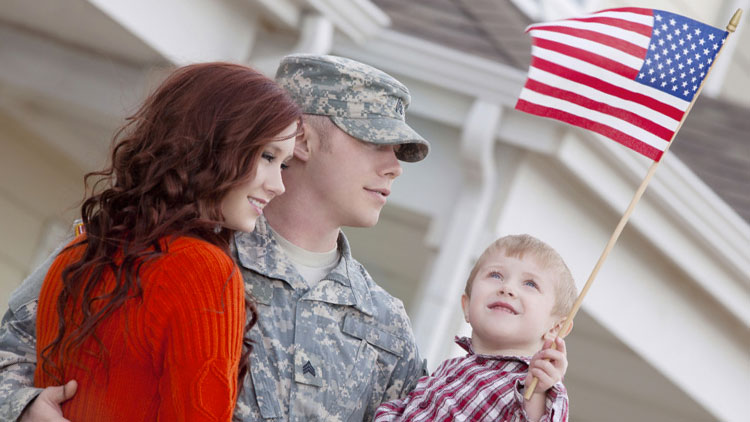 Military family with little boy holding American flag