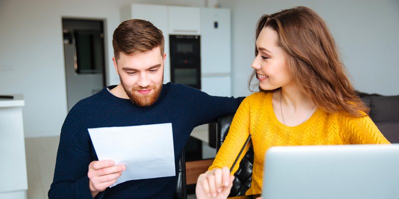 Couple looks over refinancing paperwork for mortgage