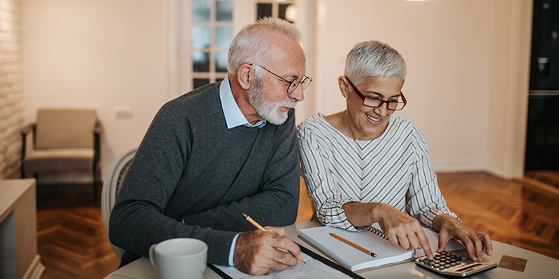 Senior Couple looks over bills happily