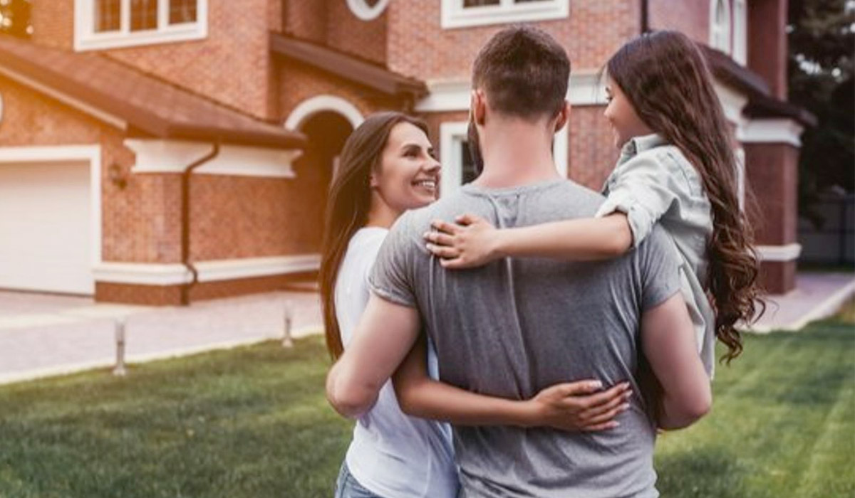 happy family in front of home