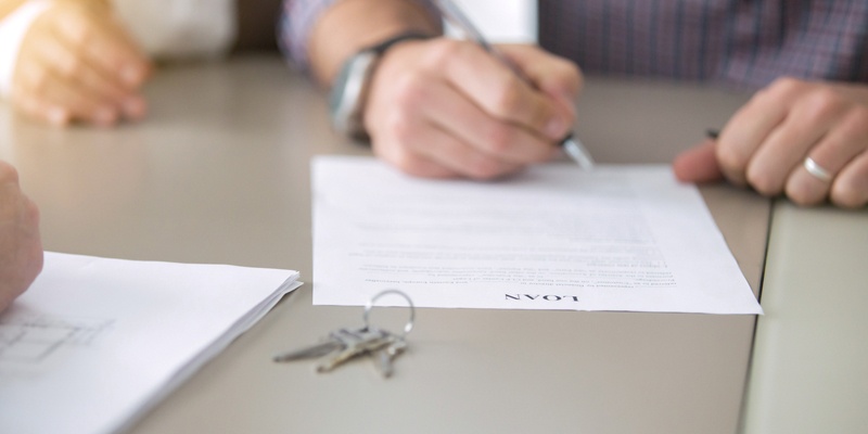 Hand filling out Loan document