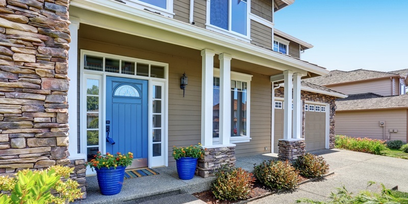 Home with Blue door, tan siding and dormers