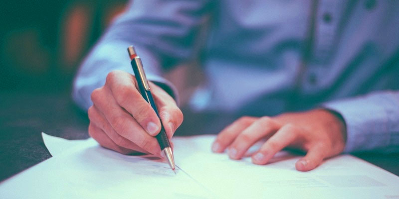 Man signing documents in business attire