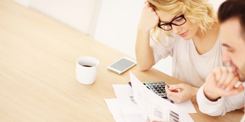 Girl looking at calculator and documents