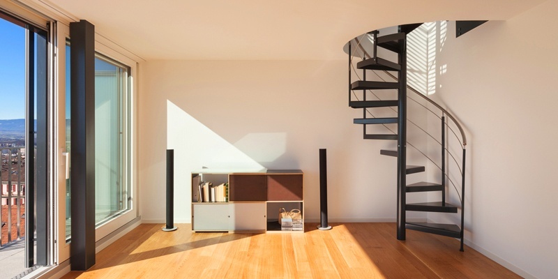 Spiral staircase with hardwood floors and excellent natural light