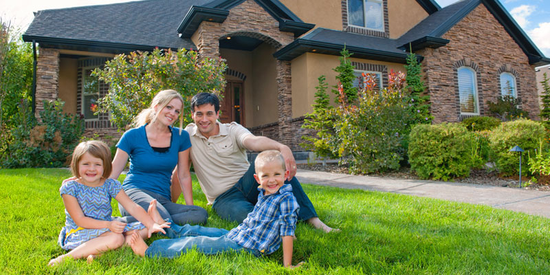 Couple on lawn in front of new home