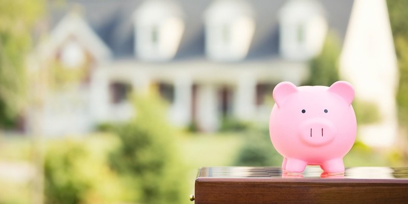 Piggy Bank in front of blurred home